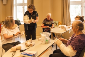 Fysioterapeut som underviser i selvbandasjering