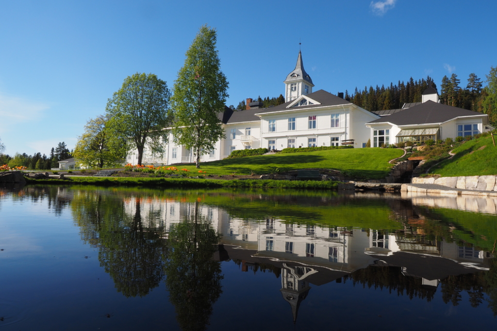 Montebellosenteret speiler seg i dammen i hagen