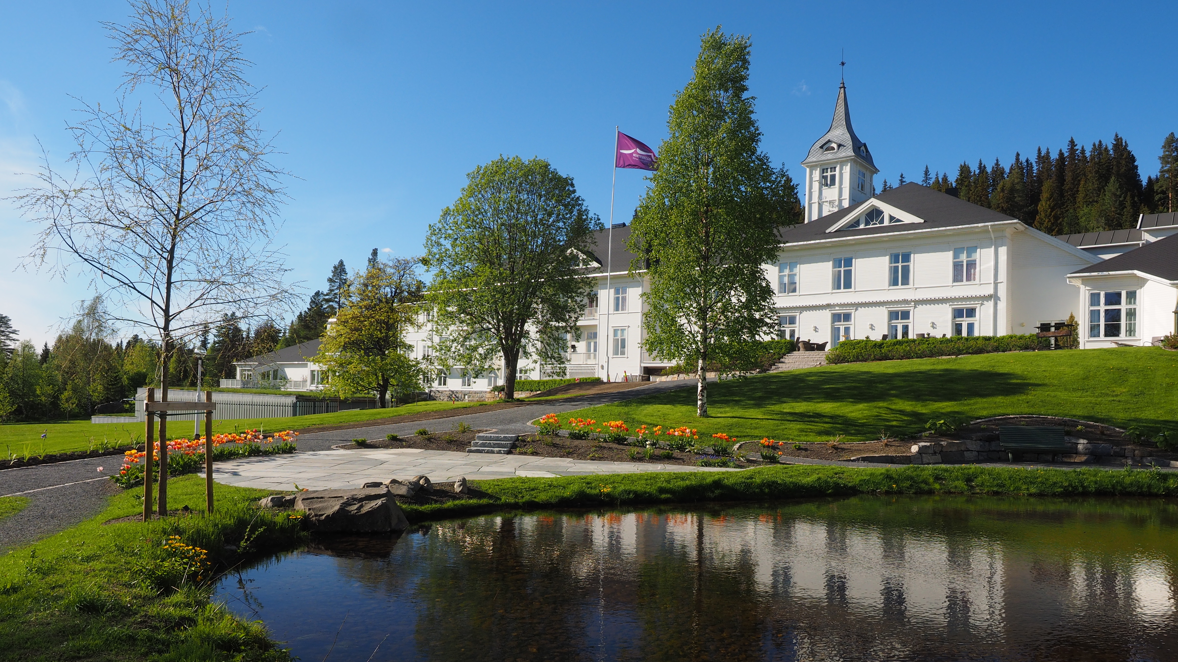 Montebellosenteret i vårstemning med tulipaner i hagen ved dammen